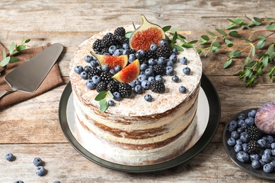 Delicious homemade cake with fresh berries served on wooden table