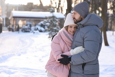 Photo of Family portrait of beautiful couple in snowy park. Space for text