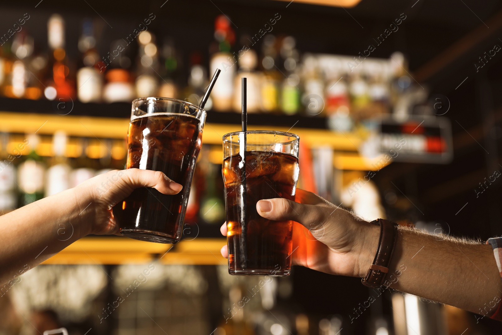 Photo of Young couple with glasses of cola in bar, closeup