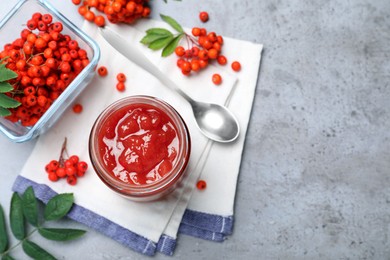 Flat lay composition with delicious rowan jam on grey table. Space for text