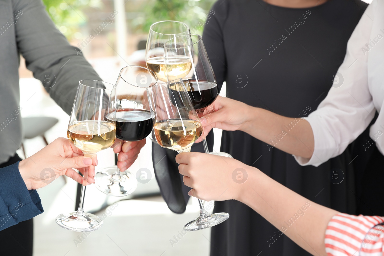 Photo of People with glasses of wine on blurred background, closeup