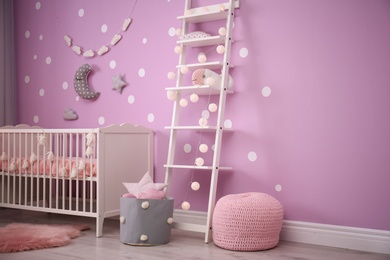 Baby room interior with crib near color wall