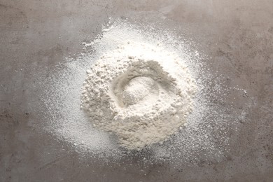 Pile of flour on grey textured table, top view