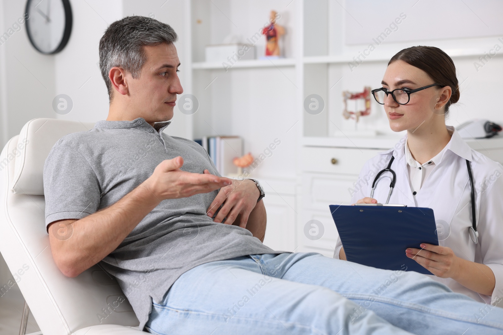 Photo of Gastroenterologist with clipboard consulting patient in clinic