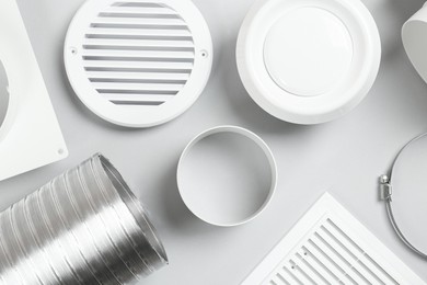 Photo of Parts of home ventilation system on light grey background, flat lay