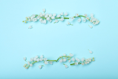 Beautiful lily of the valley flowers on light blue background, flat lay. Space for text