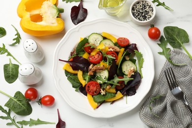 Tasty fresh vegetarian salad and ingredients on white marble table, flat lay