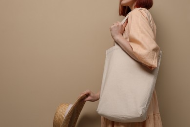 Woman with eco bag on beige background, closeup. Space for text