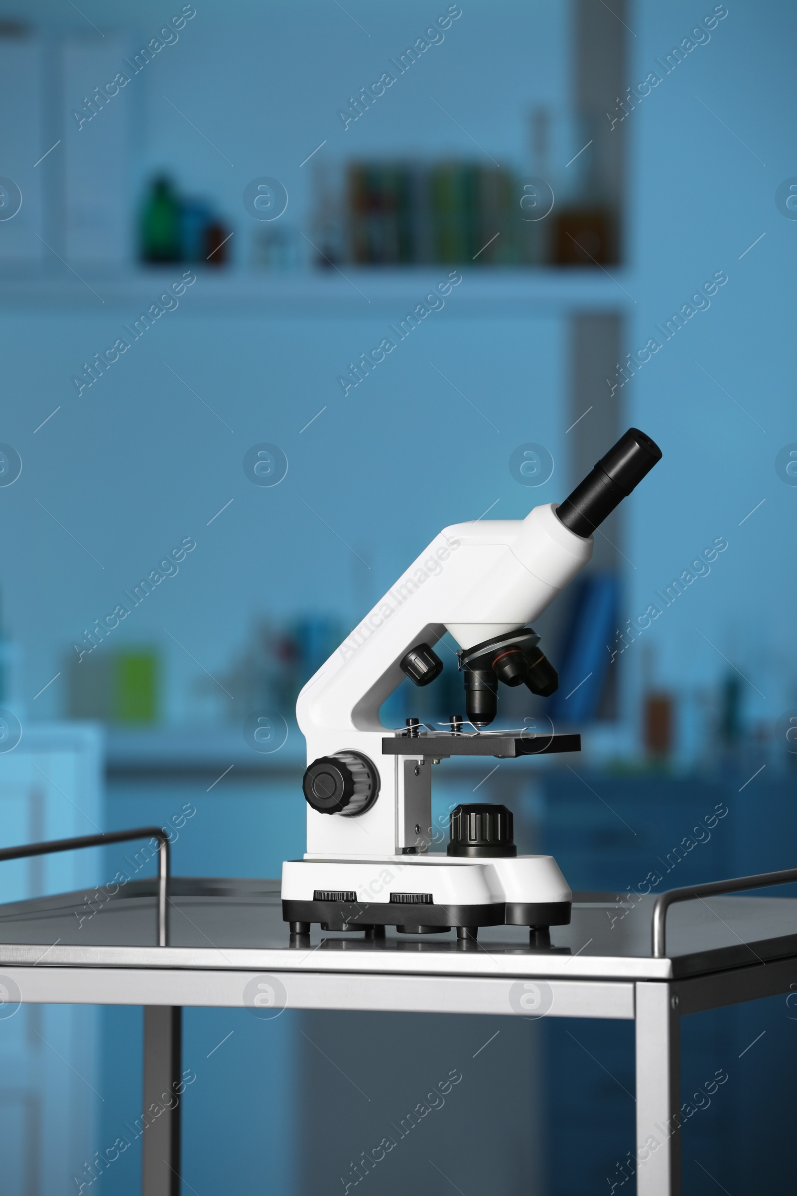 Photo of Modern medical microscope on metal table in laboratory