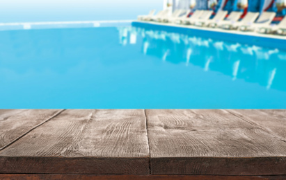 Image of Wooden deck near swimming pool outdoors on sunny day. Space for text