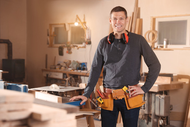 Professional carpenter with set of tools in workshop