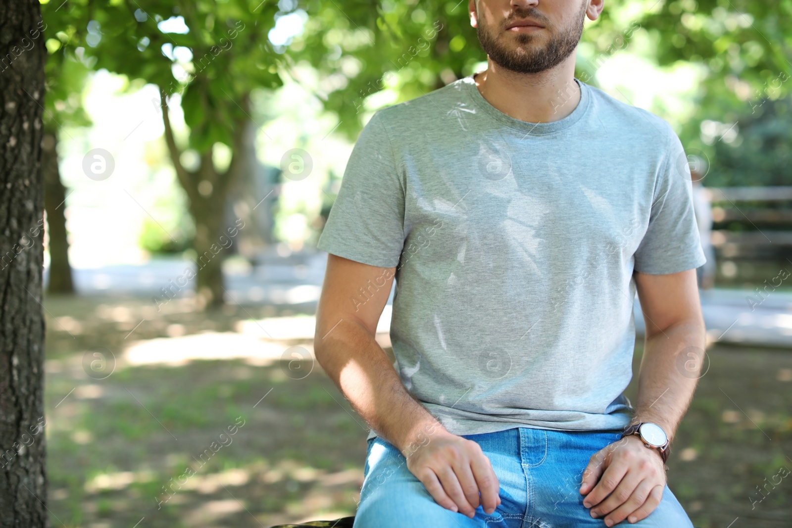 Photo of Young man wearing gray t-shirt in park. Urban style