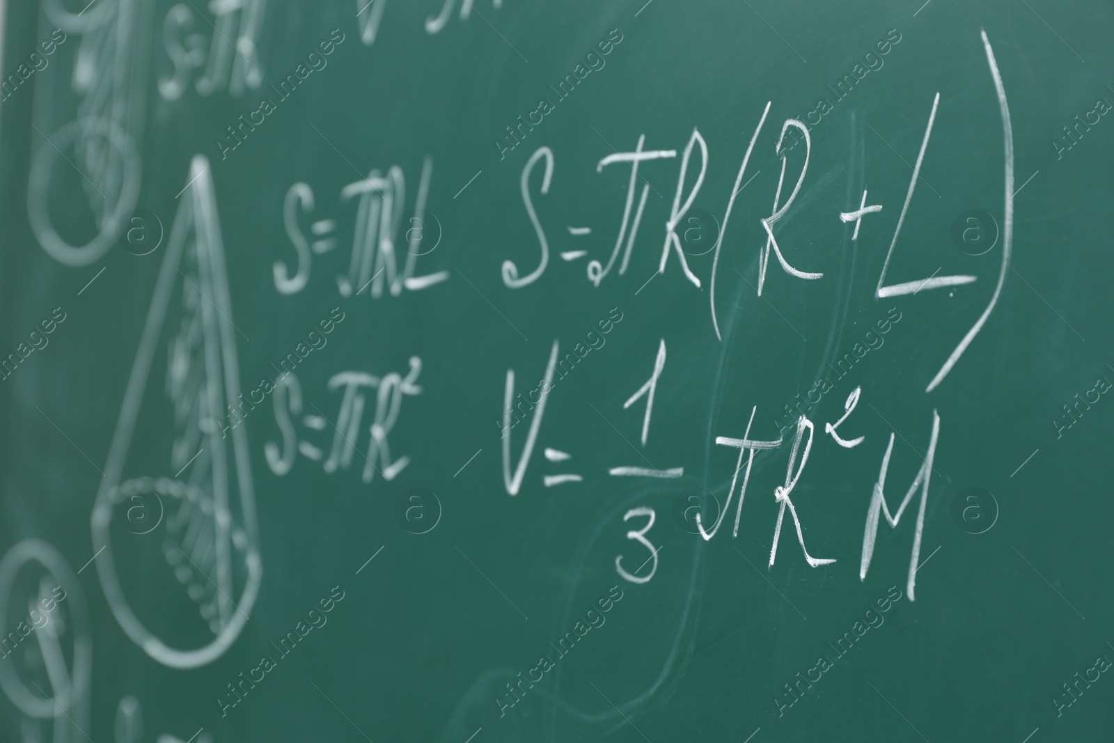 Photo of Different math formulas written with chalk on green board