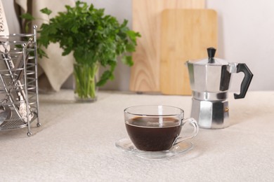 Delicious coffee in cup and moka pot on light textured table. Space for text