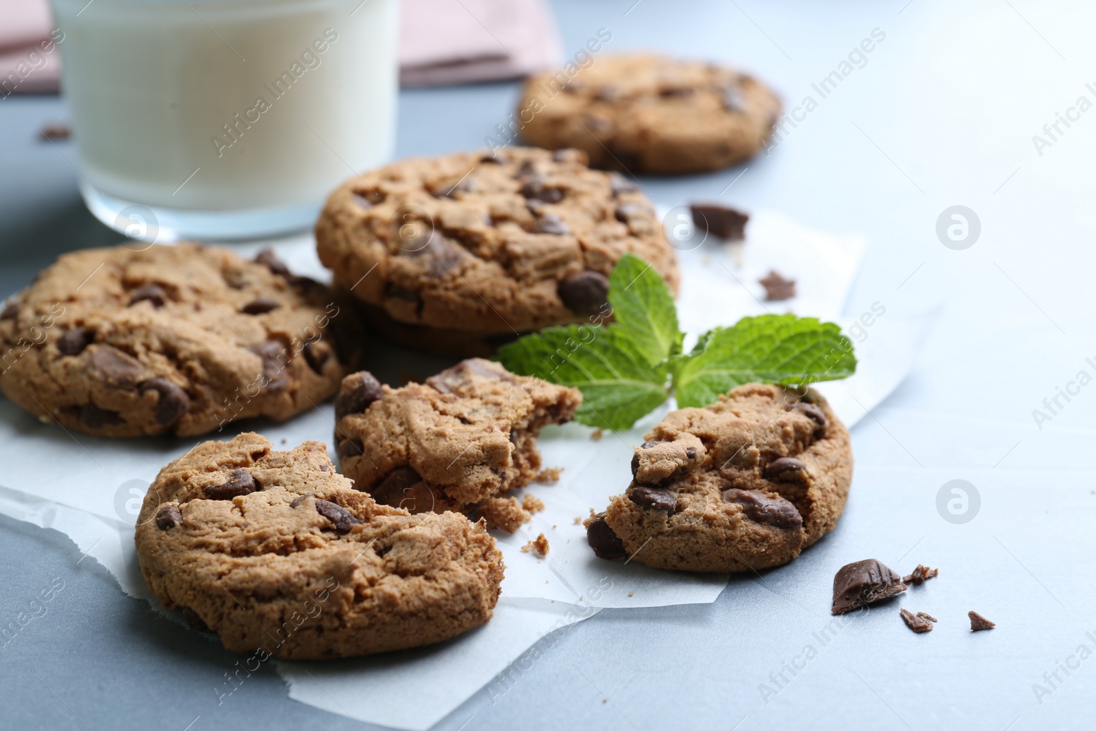 Tasty chocolate chip cookies and mint leaves on light grey table, closeup Photo of Tasty chocolate chip cookies and mint leaves on light grey table, closeup