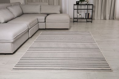 Stylish rug with pattern on floor in living room