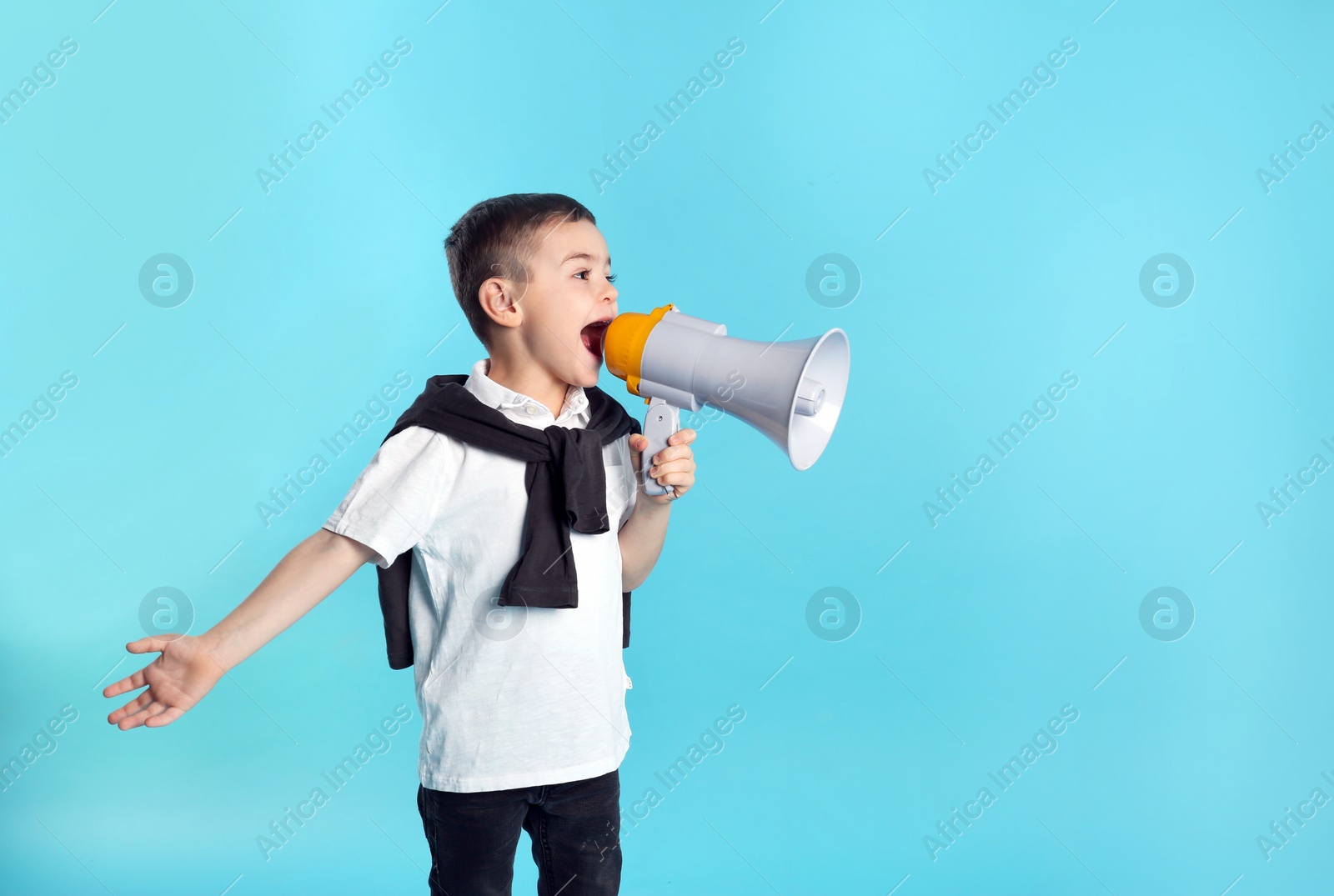 Photo of Cute funny boy with megaphone on color background. Space for text