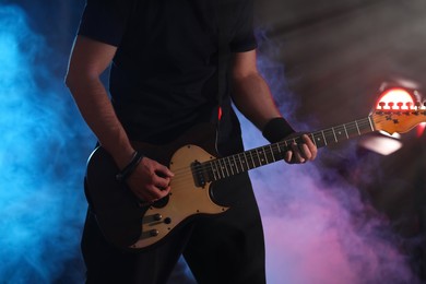 Man playing electric guitar on stage, closeup. Rock music