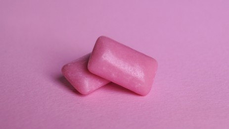 Tasty sweet chewing gums on pink background, closeup