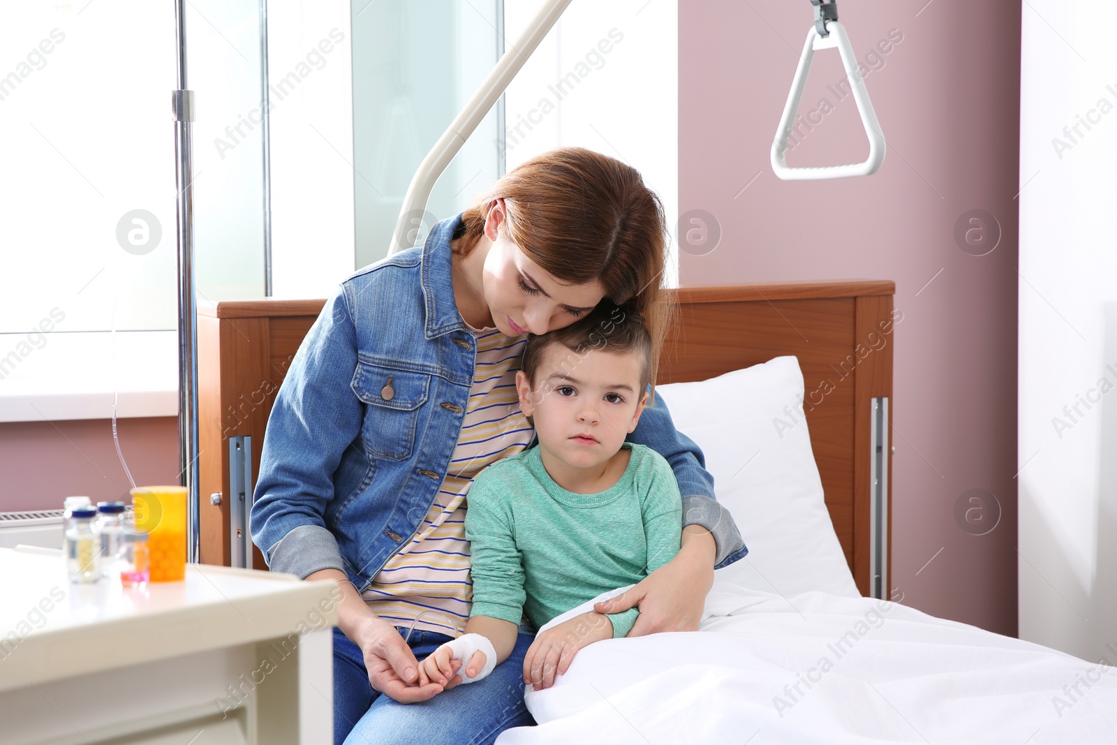 Photo of Woman visiting her little child with intravenous drip in hospital