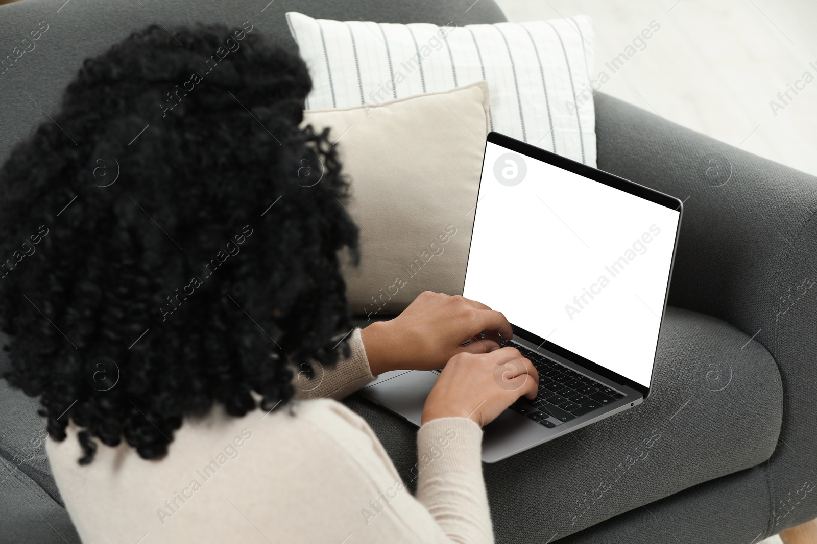 Photo of Woman using laptop on sofa at home, closeup