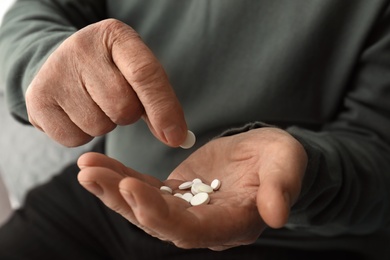 Senior man taking pills, closeup of hands