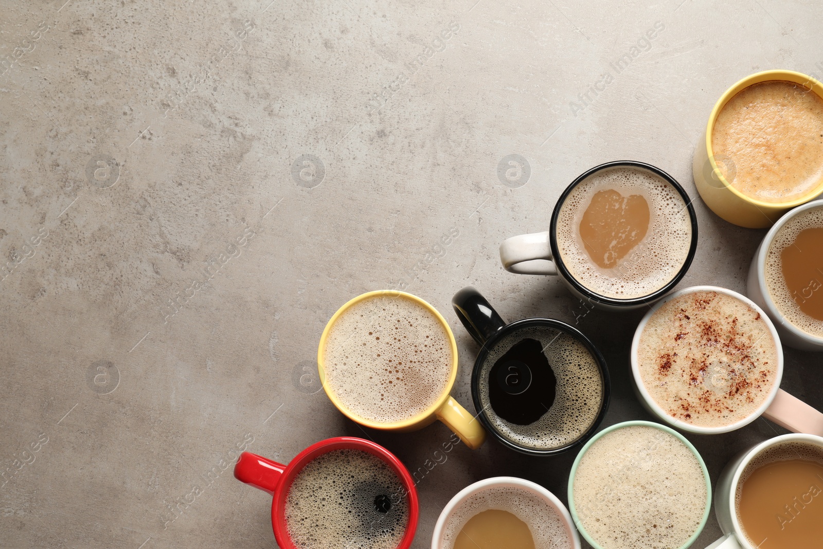 Photo of Many cups with different aromatic coffee on light grey table, flat lay. Space for text