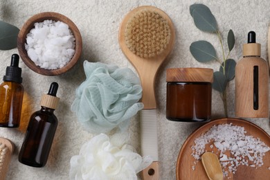 Flat lay composition with different spa products and eucalyptus branch on light grey textured table