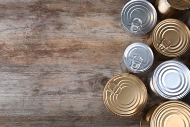 Photo of Many tin cans on wooden background, top view. Recycling garbage