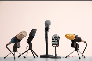 Photo of Different microphones on light grey table. Journalist's work