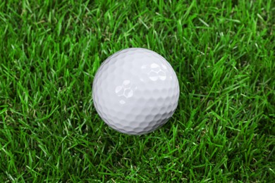 Photo of One golf ball on green grass, closeup