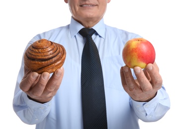 Photo of Senior man with pastry and apple on white background, closeup. Diabetes diet