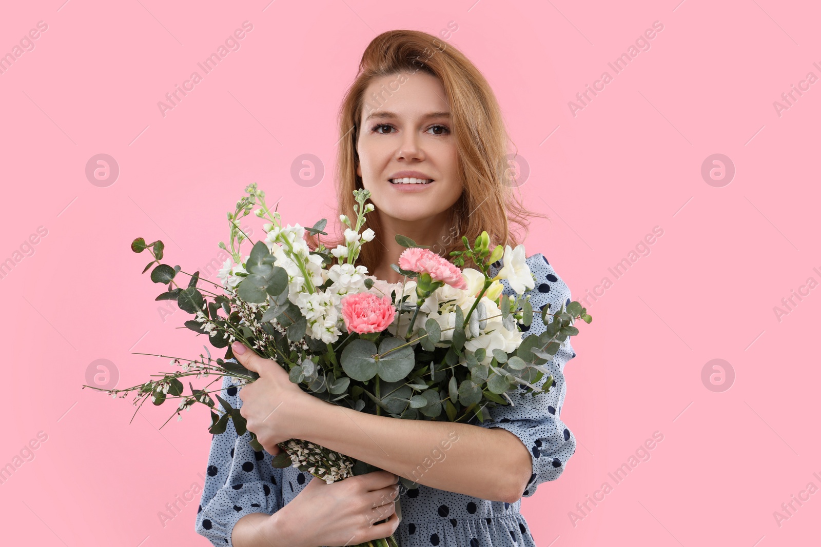 Photo of Beautiful woman with bouquet of flowers on pink background