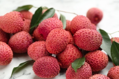 Photo of Fresh ripe lychee fruits on white table, closeup