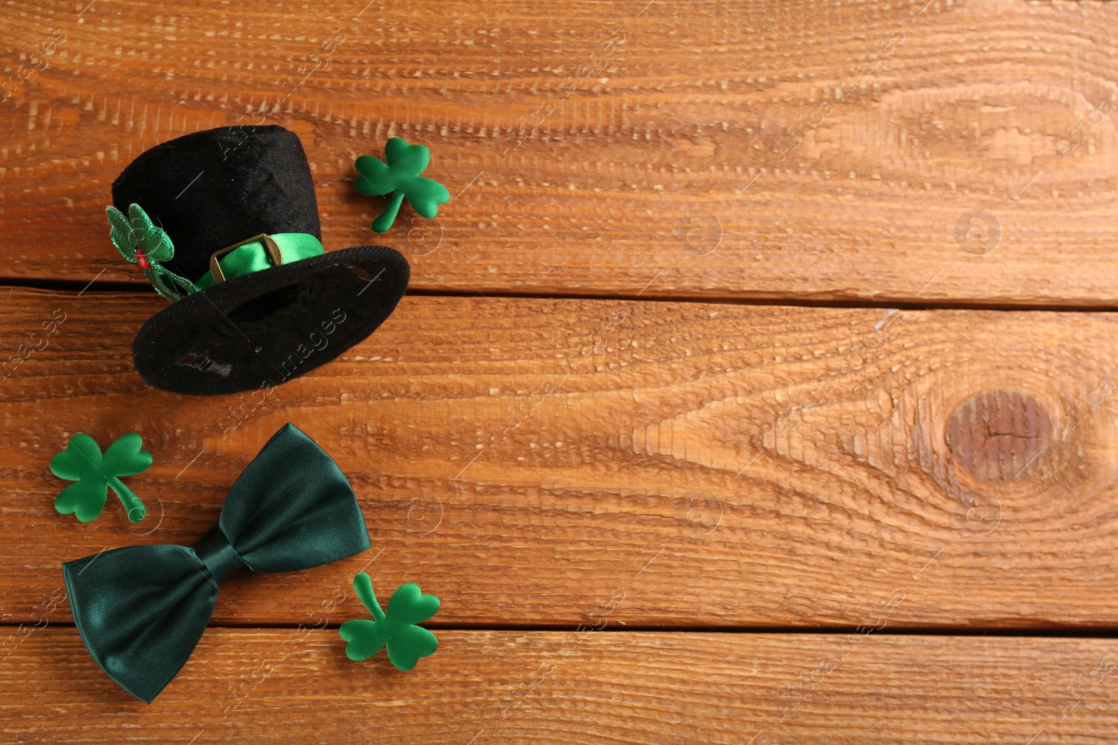 Photo of Leprechaun's hat and St. Patrick's day decor on wooden background, flat lay. Space for text