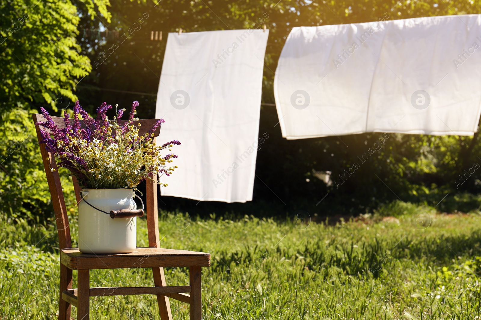 Photo of Beautiful bouquet with field flowers on chair outdoors, space for text