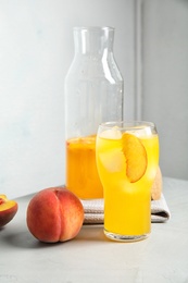 Photo of Tasty peach cocktail on table. Refreshing drink