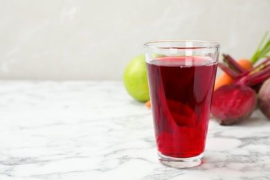 Photo of Glass with fresh beet juice on table