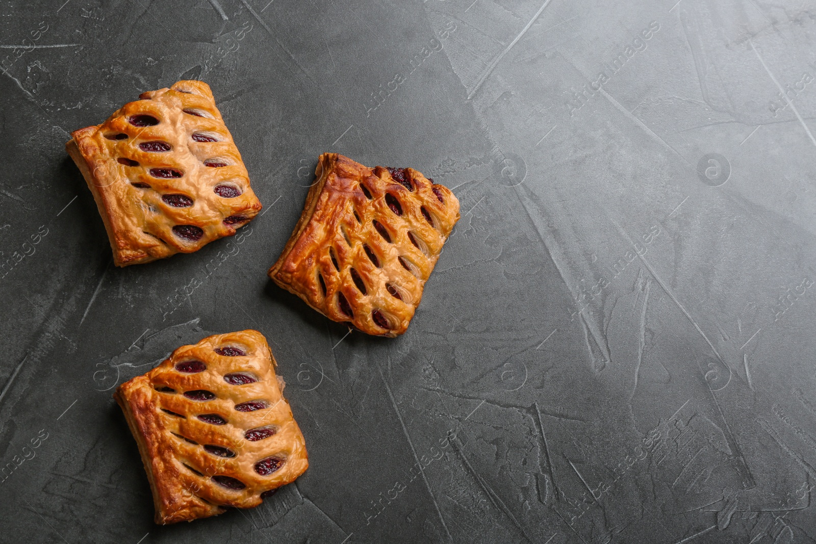 Photo of Fresh delicious puff pastry on grey table, top view. Space for text