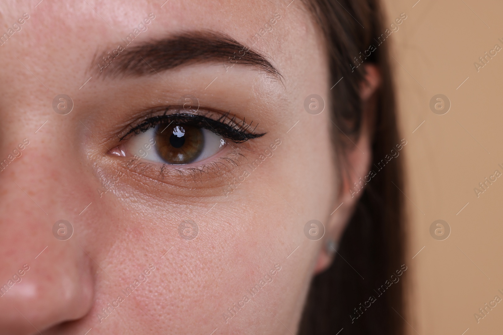 Photo of Closeup view of woman with beautiful hazel eyes on beige background