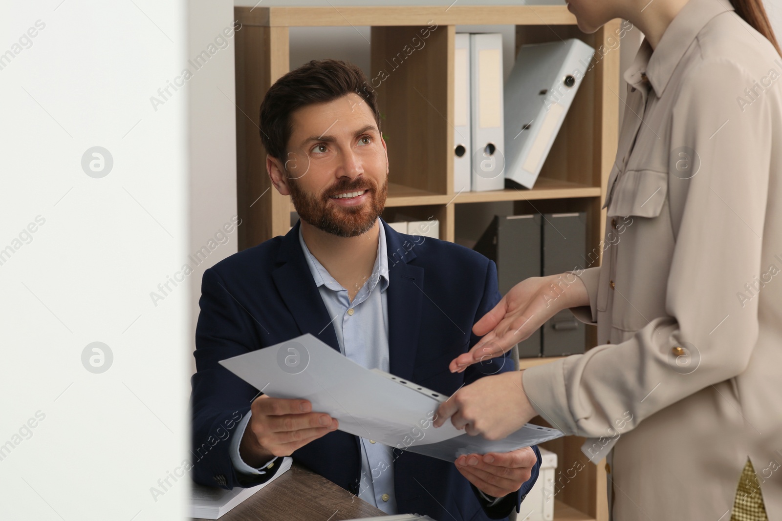 Photo of Businesspeople working together with documents in office