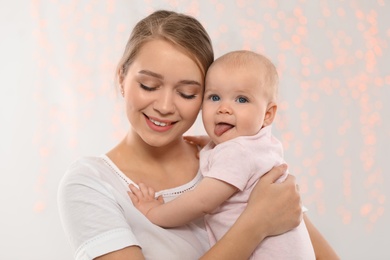 Portrait of happy mother with her baby against blurred lights