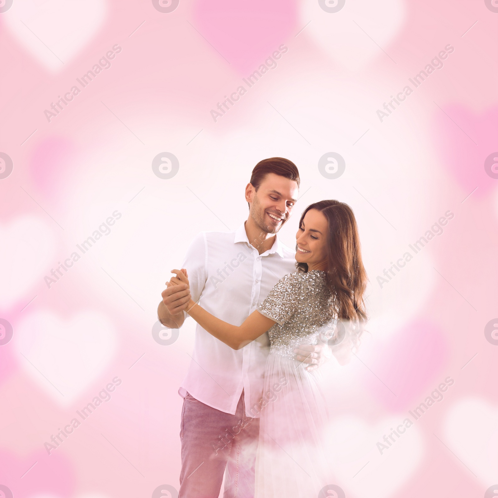 Image of Lovely young couple dancing together on pink background. Valentine's day