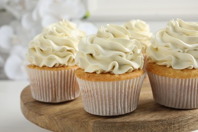 Photo of Tasty vanilla cupcakes with cream on white table, closeup