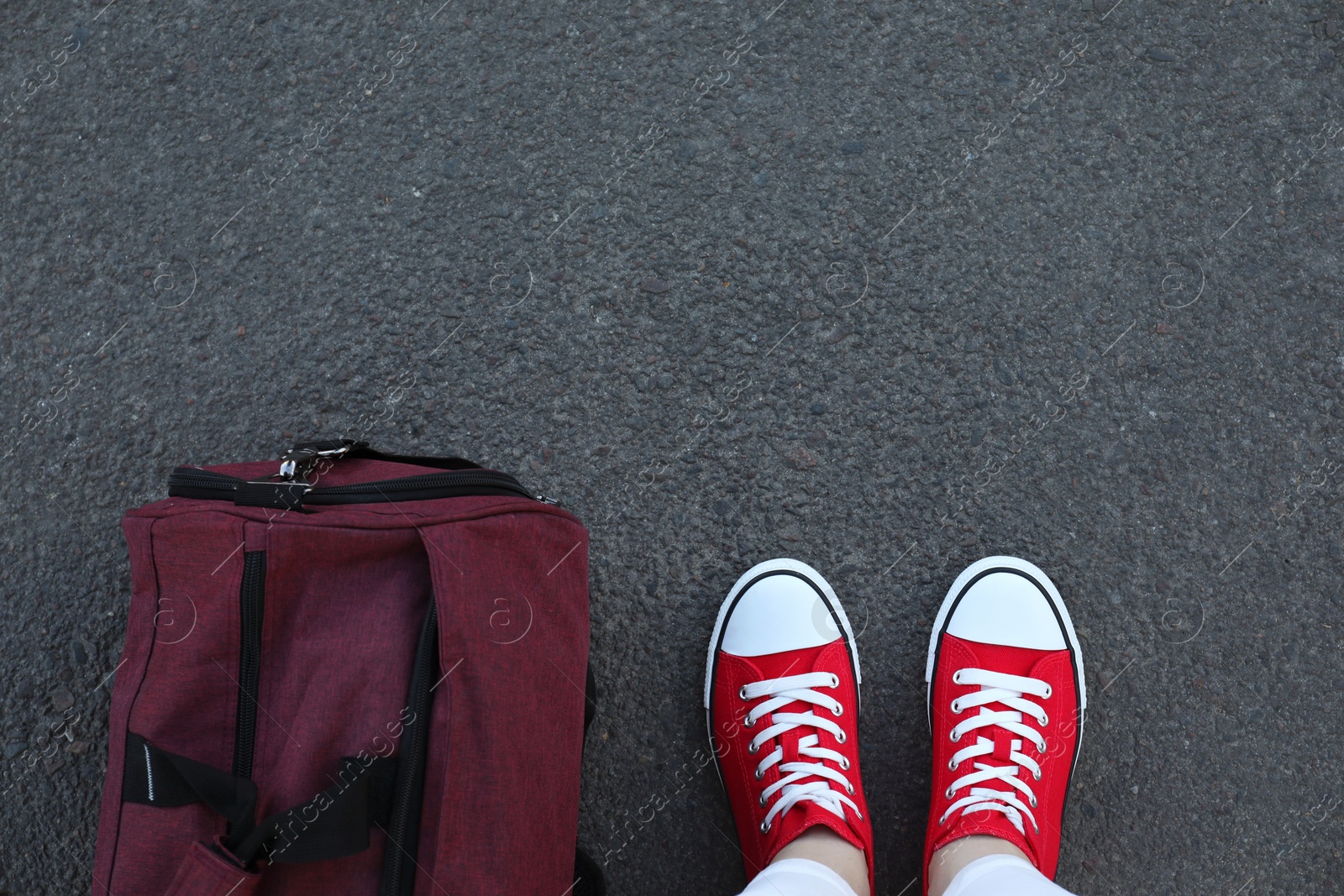 Photo of Woman with bag standing on asphalt, top view