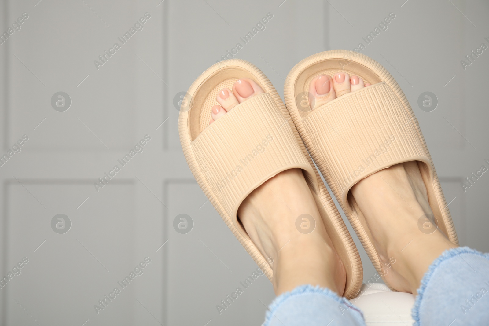 Photo of Woman wearing comfortable rubber slippers indoors, closeup