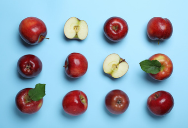 Tasty red apples on light blue background, flat lay