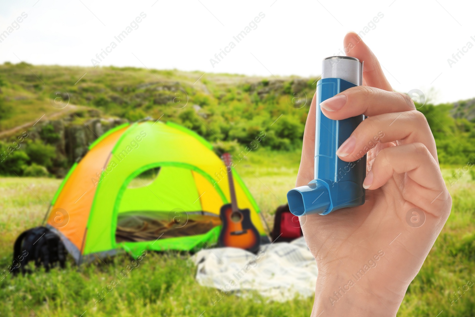Image of Young woman using asthma inhaler outside on sunny day, closeup. Emergency first aid during outdoor recreation