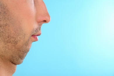 Young man with double chin on blue background, closeup. Space for text