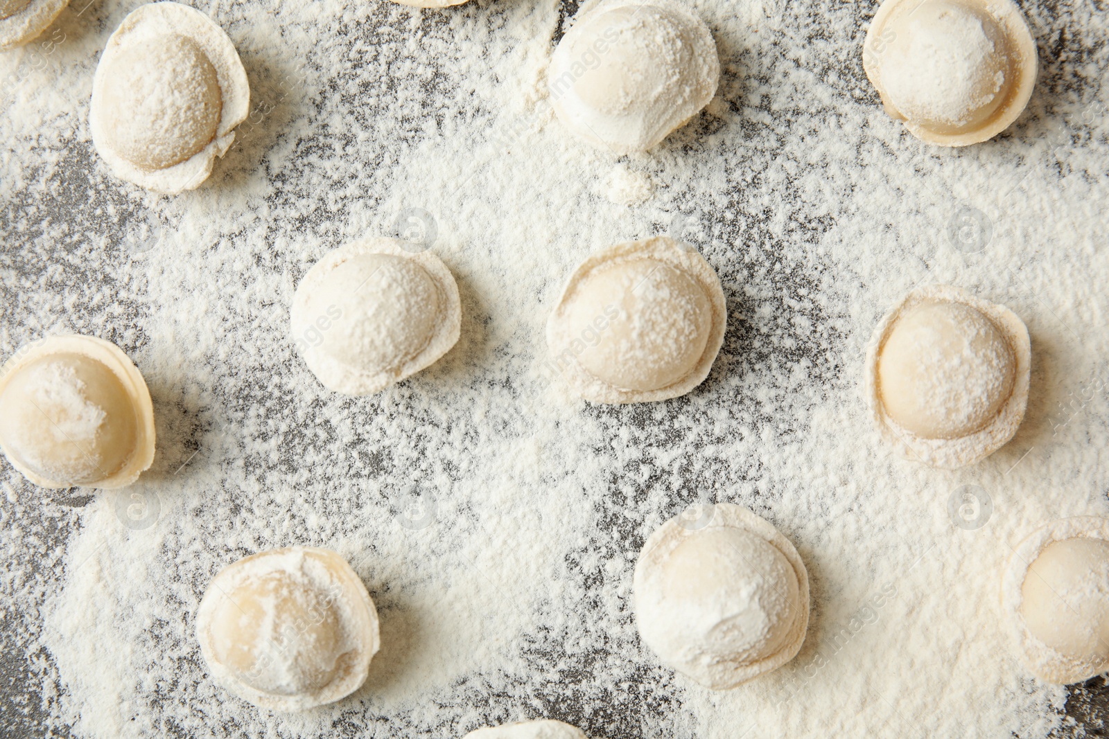 Photo of Flat lay composition with raw dumplings on grey background. Process of cooking